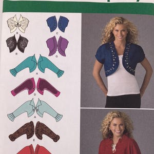May include: Simplicity sewing pattern 2478 for bolero jackets in sizes H5 6, 8, 10, 12, 14. The envelope features illustrations of various sleeve lengths and fabric styles, along with photographs of a blue embellished bolero and a red ruffled bolero.