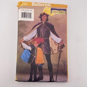 May include: A Butterick sewing pattern envelope 5656 for historical costumes. The front shows an adult and a child wearing matching outfits with capes, tunics, and feathered hats. The adult holds a sword. The text includes Making History.