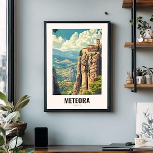 May include: Framed art print showcasing Meteora, Greece. The image displays a monastery perched on a high rock, with a colourful landscape of mountains and valleys. The print is in a black frame, and the word "METEORA" is printed at the bottom.