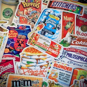 May include: A collage of vintage-style stickers with various designs. Featured stickers include "Cherry Bombs" candy, "Polar Spring" ice water, "Fruity Peppers" cereal, and a "Starbucks Coffee" cup. The stickers have a retro aesthetic.