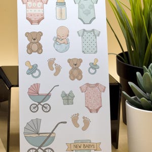 Könnte beinhalten: Eine Karte mit Baby-Illustrationen. Die Bilder zeigen Strampler, eine Babyflasche, ein Baby, Teddybären, Schnuller, Fußabdrücke, einen Kinderwagen, ein Geschenk und den Text "NEW BABYS". Die Farbpalette ist weich, mit Rosa-, Blau- und Beigetönen.