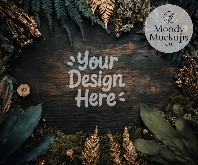 May include: A dark wood surface surrounded by green and gold foliage, moss, and dried plants. The text "Your Design Here" is in the center, with a circular logo that reads "Moody Mockups co." in the upper right corner.