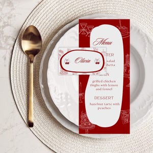 May include: A formal place setting with a gold spoon, white plates, and a red menu card. The menu card features a white oval with the word "Menu" and a list of dishes. A name card with the name "Olivia" is also present.
