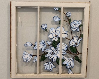 Magnolia branches painted on old wooden window