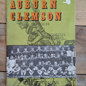 May include: Vintage Auburn vs. Clemson football game program. The cover features the text "AUBURN CLEMSON" in orange letters on a green background, with a football player illustration. Below is a black and white team photo.