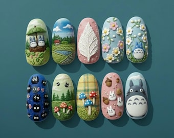 Könnte beinhalten: Ein Set aus zehn Nagelkunst-Designs mit verschiedenen skurrilen Szenen und Charakteren. Zu den Designs gehören Totoro, Landschaften, Blätter, Blumen und Pilze. Die Nägel sind in einer Vielzahl von Farben bemalt, darunter Blau, Rosa, Grün und Gelb.