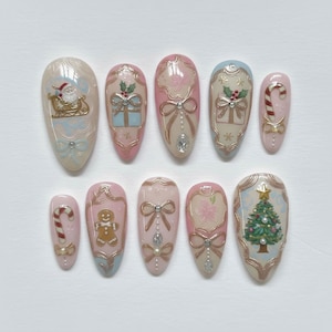 May include: A set of ten almond-shaped press-on nails with a Christmas theme. Designs include Santa in a sleigh, wrapped gifts, candy canes, gingerbread man, bows, and a Christmas tree. Colors are pink, gold, white, and blue.