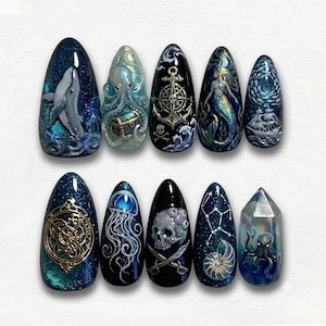 May include: A set of ten long, almond-shaped nail designs with a nautical theme. Each nail features intricate, hand-painted artwork, including a whale, octopus, treasure chest, anchor, mermaid, ship, jellyfish, skull, constellation, and an octopus inside a crystal.