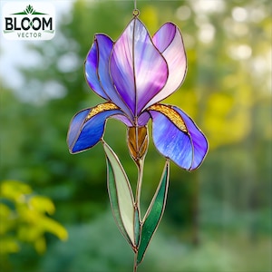 May include: A stained glass iris flower with purple, blue, and white petals, accented with gold and green. The flower is suspended by a wire, with the "BLOOM VECTOR" logo in the upper left corner. The background is blurred green.
