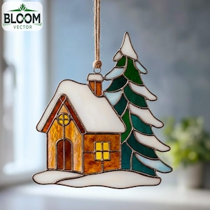 May include: A stained glass Christmas ornament featuring a cozy house and a snow-covered evergreen tree. The house has a yellow window and a chimney. The ornament is suspended by a natural twine string. The Bloom Vector logo is in the upper left corner.