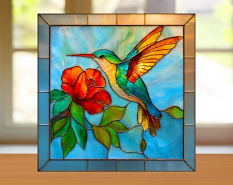 Puede incluir: Panel de vidriera con un colibrí vibrante con las alas extendidas, alimentándose de una flor roja. El ave tiene plumaje colorido en tonos verdes, azules, naranjas y amarillos. El fondo es azul claro con un borde decorativo.