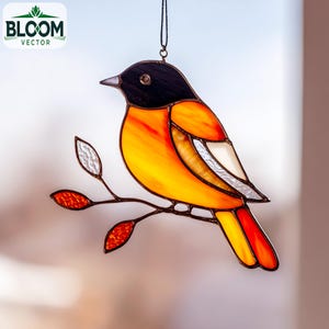 May include: Stained glass bird ornament with a black head, orange and yellow body, and red tail. The bird is perched on a brown branch with leaves. The Bloom Vector logo is in the upper left corner.