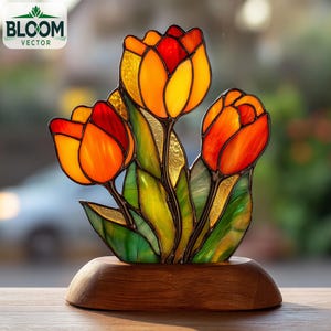 May include: A stained glass tulip sculpture with three flowers in shades of orange and red, with green leaves. The sculpture is set on a wooden base. The Bloom Vector logo is in the upper left corner.