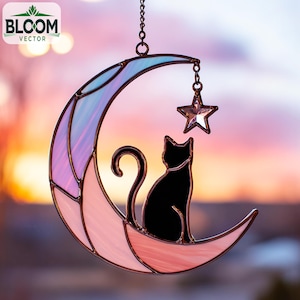 Op de afbeelding: Een gebrandschilderde maanvormige suncatcher met een zwart katten silhouet en een hangende ster. De maan is roze, paars en blauw, met een ketting om op te hangen. Het Bloom Vector logo is zichtbaar.