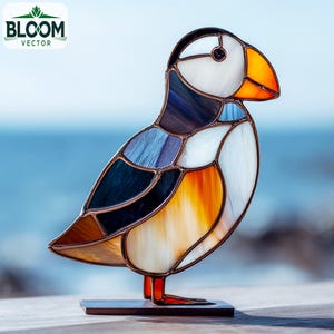 Puede incluir: Escultura de frailecillo de vidriera con cabeza blanca, pico naranja y cuerpo colorido. El ave está montada sobre una pequeña base de madera oscura. El logotipo de Bloom Vector está en la esquina superior izquierda.