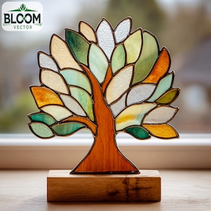 May include: Stained glass tree sculpture with a wooden base. The tree features a brown trunk and branches, with colorful leaves in shades of green, yellow, and orange. The sculpture is displayed on a wooden block.