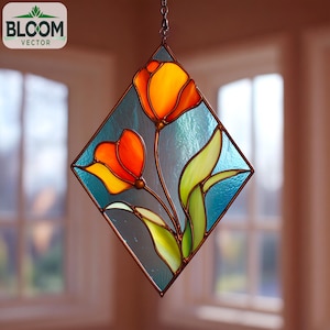 May include: A stained glass window hanging featuring two orange and yellow tulips with green leaves. The flowers are set against a blue background within a diamond-shaped frame. The Bloom Vector logo is in the upper left corner.