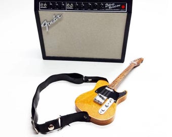 Guitarra eléctrica en miniatura con amplificador y correa para decoración de exhibición, acabado natural.