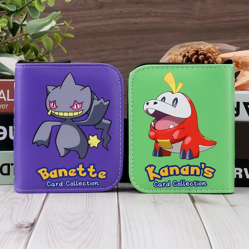 May include: Two card collection binders. One is purple with a Banette graphic and the text "Banette Card Collection". The other is green with a Kanan's graphic and the text "Kanan's Card Collection".