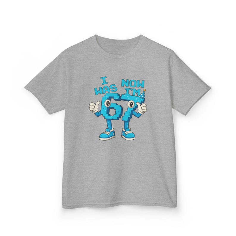 Pu&ograve; includere: T-shirt grigia con grafica blu raffigurante i numeri 6 e 7 come personaggi dei cartoni animati con i pollici in su e scarpe, con la scritta "I WAS 67 NOW I'M".