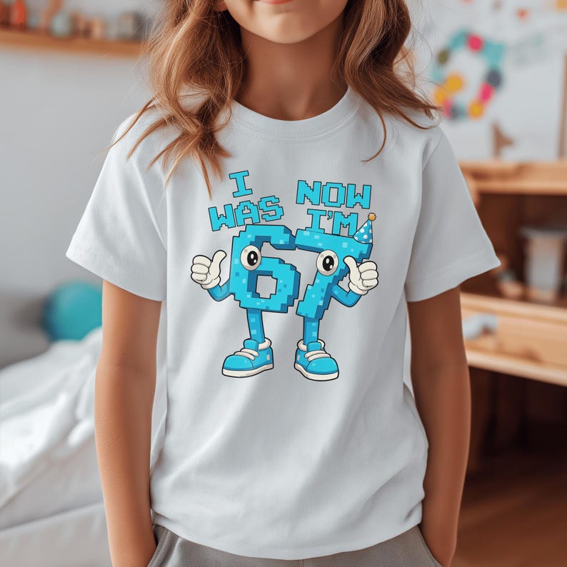 Pu&ograve; includere: T-shirt bianca con una grafica a cartoni animati con la scritta "I WAS 6 NOW I'M 67". Il numero 6 fa il pollice in su e indossa scarpe blu. Il numero 7 indossa un cappello da festa e fa il pollice in su.