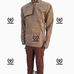 May include: A two-piece outfit featuring a tan long-sleeve shirt with a unique collar and a front pocket, paired with rust-colored cargo pants. The outfit is displayed on a mannequin, showcasing the design and fit of the clothing.