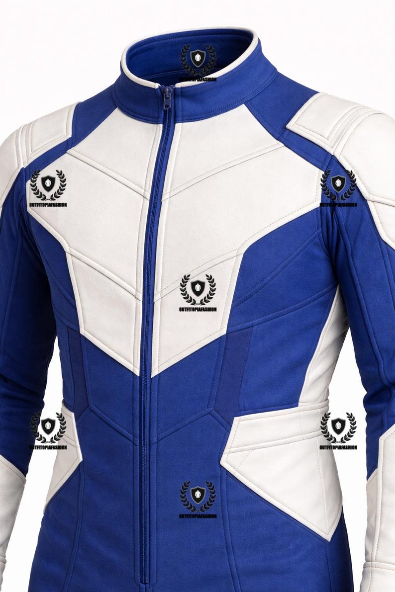 May include: A blue and white jacket with a high collar and a full-length zipper. The jacket features a geometric design with white panels and blue sections. The jacket has a sporty, modern aesthetic.