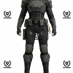 May include: A full-body black tactical outfit, including a jacket with shoulder pads, pants, and combat boots. The outfit features multiple pockets, a belt, and knee pads. The mannequin is wearing black gloves. The outfit is designed for protection and utility.