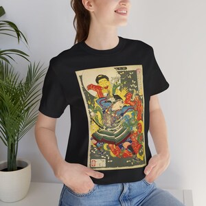 Puede incluir: Camiseta negra con una colorida impresión japonesa. La obra de arte representa una figura con vestimenta tradicional, rodeada de criaturas míticas y follaje. El diseño incluye tonos de rojo, azul, verde y amarillo.