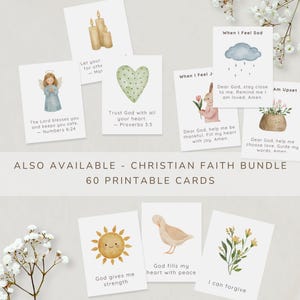 May include: A collection of white rectangular cards featuring watercolor illustrations of religious and nature themes, including an angel, candles, a heart, a rabbit, a sun, and flowers, with printed text and scripture verses on each individual card.