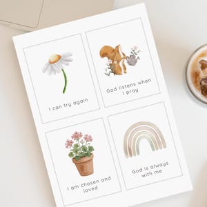 May include: A white rectangular sheet featuring four distinct cards with watercolor illustrations and text. The cards display a daisy with 'I can try again', a squirrel with 'God listens when I pray', a potted plant with 'I am chosen and loved', and a rainbow with 'God is always with me'.