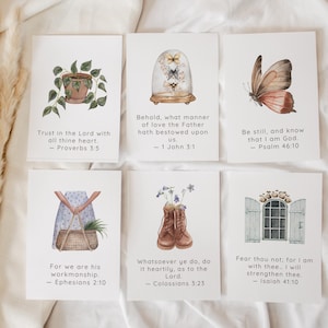 Peut inclure: Six impressions d'art à l'aquarelle avec des citations inspirantes. Les impressions présentent des illustrations d'une plante en pot, de papillons dans un dôme en verre, d'un papillon, d'une personne tenant un panier, de bottes avec des fleurs et d'une fenêtre. Chaque impression comprend un verset biblique.