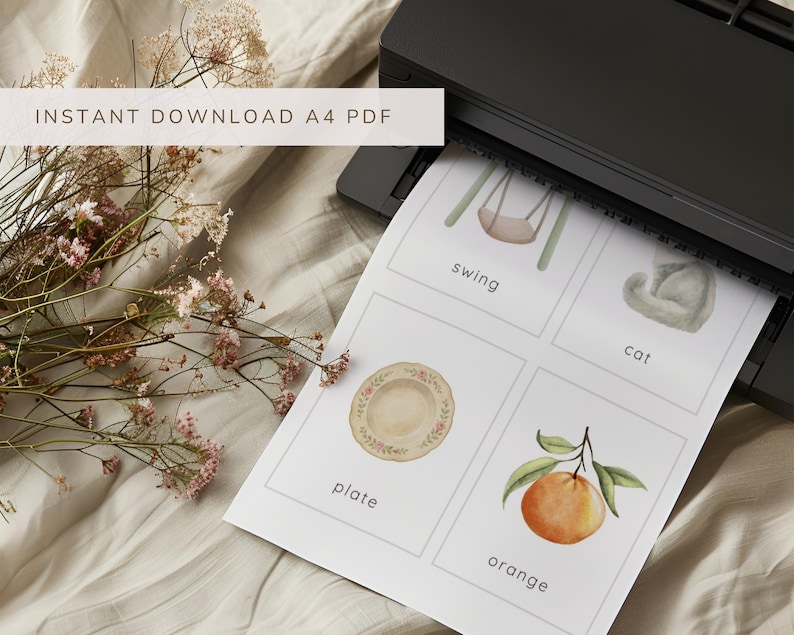 May include: A4 PDF print with watercolor illustrations of a swing, cat, plate, and orange. The print is coming out of a black printer. Text at the top reads "INSTANT DOWNLOAD A4 PDF".