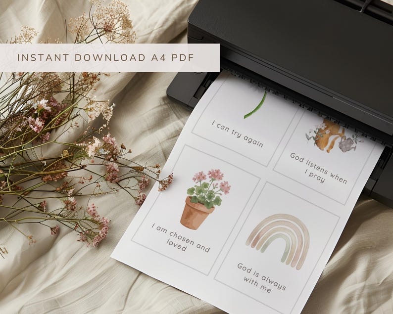 May include: A black printer outputting a white A4 sheet of paper featuring four rectangular cards with watercolor illustrations and text. The cards display a green sprout, a fox, a potted geranium, and a rainbow, with the phrases I can try again, God listens when I pray, I am chosen and loved, and God is always with me.