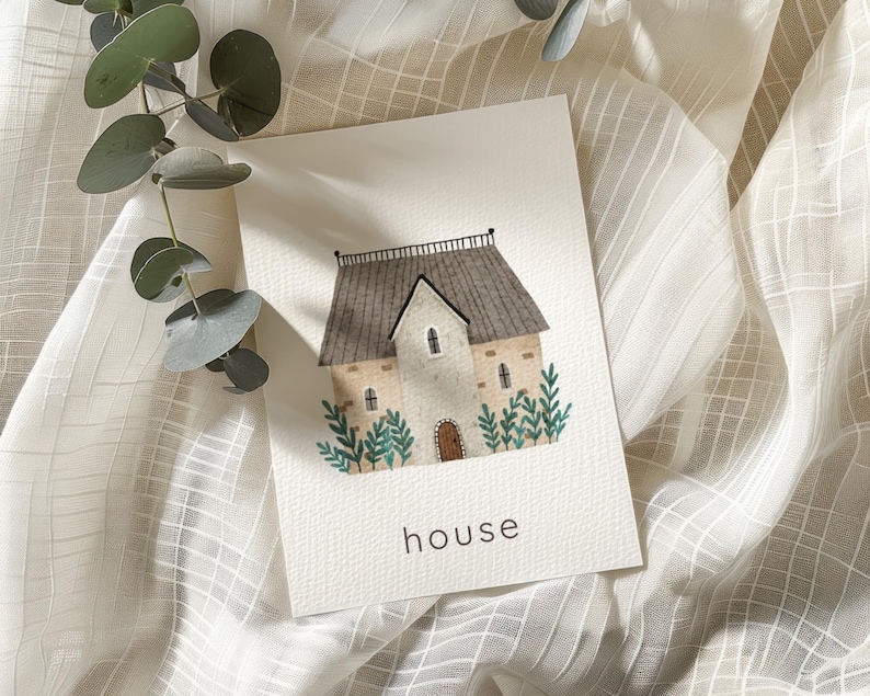 May include: Watercolor illustration of a house with a gray roof, tan walls, and a brown door. Green foliage surrounds the house. The word "house" is written in black at the bottom of the image. Eucalyptus leaves are in the upper left corner.