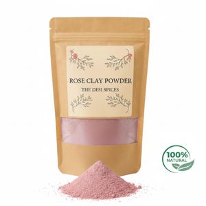 May include: A kraft paper pouch of rose clay powder. The label reads "ROSE CLAY POWDER" and "THE DESI SPICES". A small pile of pink powder is in front of the pouch. A green and white "100% NATURAL" sticker is on the right.
