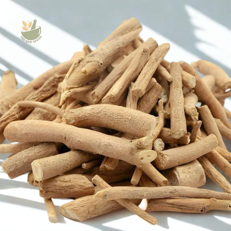 May include: A pile of light brown, dried ashwagandha roots. The roots vary in size and shape, with some appearing thicker and more gnarled than others. The image is well-lit, highlighting the texture and natural color of the roots. The Best Spices logo is in the upper left corner.