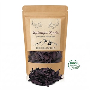 Peut inclure: Un sachet en papier kraft avec une fenêtre transparente, rempli de racines de Ratanjot violet foncé. L'étiquette indique "Ratanjot Roots (Onosma echioides)" au-dessus d'une illustration de montagne et "THE DESI SPICES". Un cercle vert avec "100% NATURAL" est à droite.