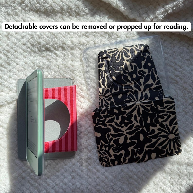 May include: A light green e-reader with a red and pink striped stand, alongside a detachable black and beige floral patterned cover. The text "Detachable covers can be removed or propped up for reading." is visible at the top of the image.