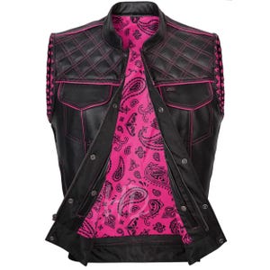 Puede incluir: Chaleco de cuero negro con costuras rosas y forro rosa con estampado de cachemira. El chaleco presenta un diseño acolchado en los hombros y el pecho, dos bolsillos delanteros y cierre de cremallera. Cuello alzado y trenzado decorativo en los laterales.