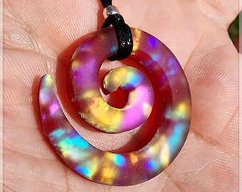 Medium sandblasted dichroic fused glass spiral rainbow galaxy on red translucent pendant
