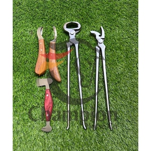 Peut inclure: Ensemble d'outils de maréchal-ferrant, comprenant des couteaux à sabot avec manches en bois, des pinces et un marteau avec un manche rouge et marron, disposés sur une surface verte. Les outils sont en métal et en bois.