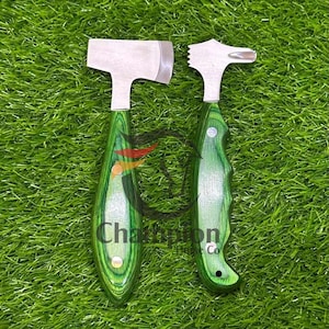 Puede incluir: Dos ablandadores de carne de acero inoxidable con mangos de madera verde. Uno tiene una cabeza plana, el otro una cabeza texturizada. Los mangos son de un verde vibrante con un patrón de vetas de madera. Las herramientas se exhiben sobre hierba verde.