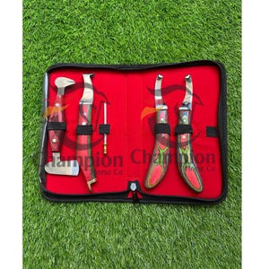Peut inclure: Un étui noir zippé avec un intérieur rouge contenant des outils de maréchal-ferrant. Les outils comprennent des couteaux à pieds, un cure-pieds et une râpe. Les manches sont en bois avec des accents rouges et verts.