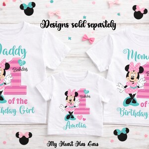 K&ouml;nnte beinhalten: Wei&szlig;e T-Shirts mit Minnie-Maus-Designs f&uuml;r einen ersten Geburtstag. Die Shirts sind mit "Daddy", "Mommy" und "Amelia" beschriftet, mit passenden Minnie-Maus-Grafiken und der Zahl "1". Rosa und t&uuml;rkisfarbene Akzente werden verwendet.
