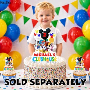 May include: A cake topper and four cupcake toppers featuring a colorful cartoon character graphic, a black Mickey Mouse ear silhouette with the number 2, and the text "MICHAEL'S CLUBHOUSE" in a vibrant, multi-colored font on a white background.