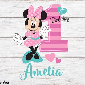 K&ouml;nnte beinhalten: Eine rosa und t&uuml;rkisfarbene Grafik zum ersten Geburtstag. Minnie Mouse tr&auml;gt ein rosa gepunktetes Kleid und eine Schleife. Die Zahl eins ist rosa mit Streifen. Der Name "Amelia" ist t&uuml;rkis geschrieben.