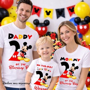 May include: White t-shirts with Mickey Mouse graphics for a family. The shirts say "Daddy", "Mommy", and "Oh Two-dles" with the number "2" and Mickey Mouse. The shirts are for a birthday celebration.