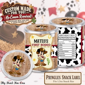 May include: Two cylindrical snack containers with custom labels featuring a cartoon mouse in cowboy attire. The labels display the text MATEO'S FIRST RODEO and a nutrition facts table for a birthday boy. The design includes a cow print pattern.