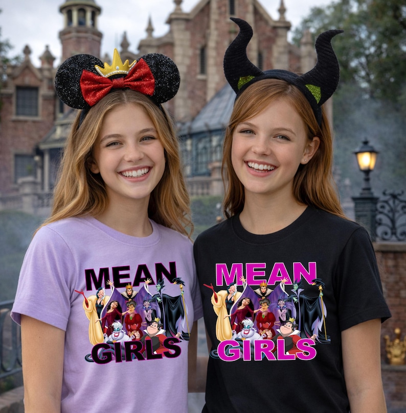 K&ouml;nnte beinhalten: Zwei l&auml;chelnde Personen tragen Themen-Stirnb&auml;nder und T-Shirts. Einer tr&auml;gt ein Minnie-Mouse-Ohren-Stirnband mit roter Schleife, der andere ein schwarzes Horn-Stirnband. Die Shirts tragen die Aufschrift "MEAN GIRLS" mit einer Grafik von Disney-B&ouml;sewichten.